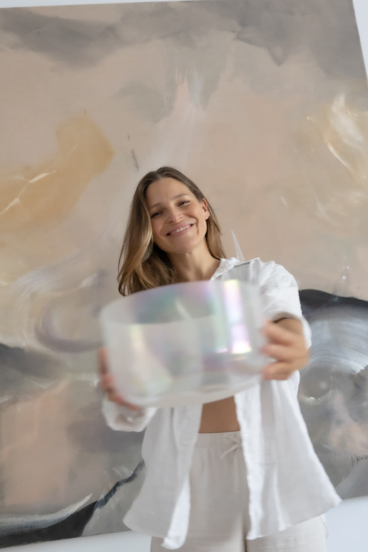 Woman dancing with her arms raised in a white shirt, blurred in motion and sunlight