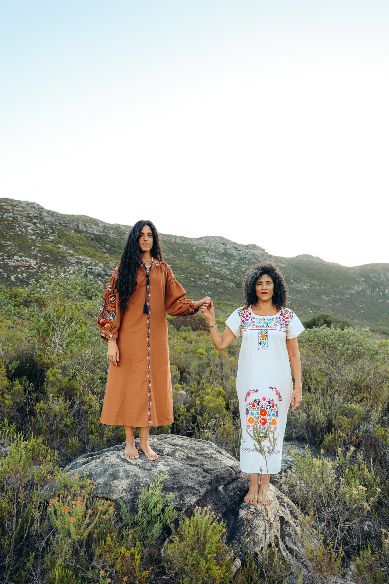 Mother and daughter holding hands on a rocky hill