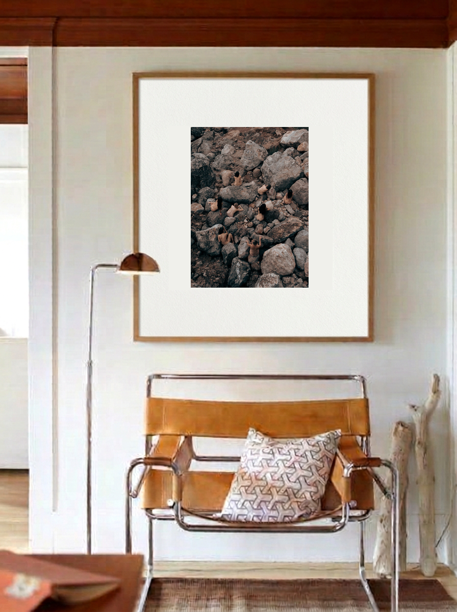 Stone Sisters print in a wooden frame with a white mat above a leather chair