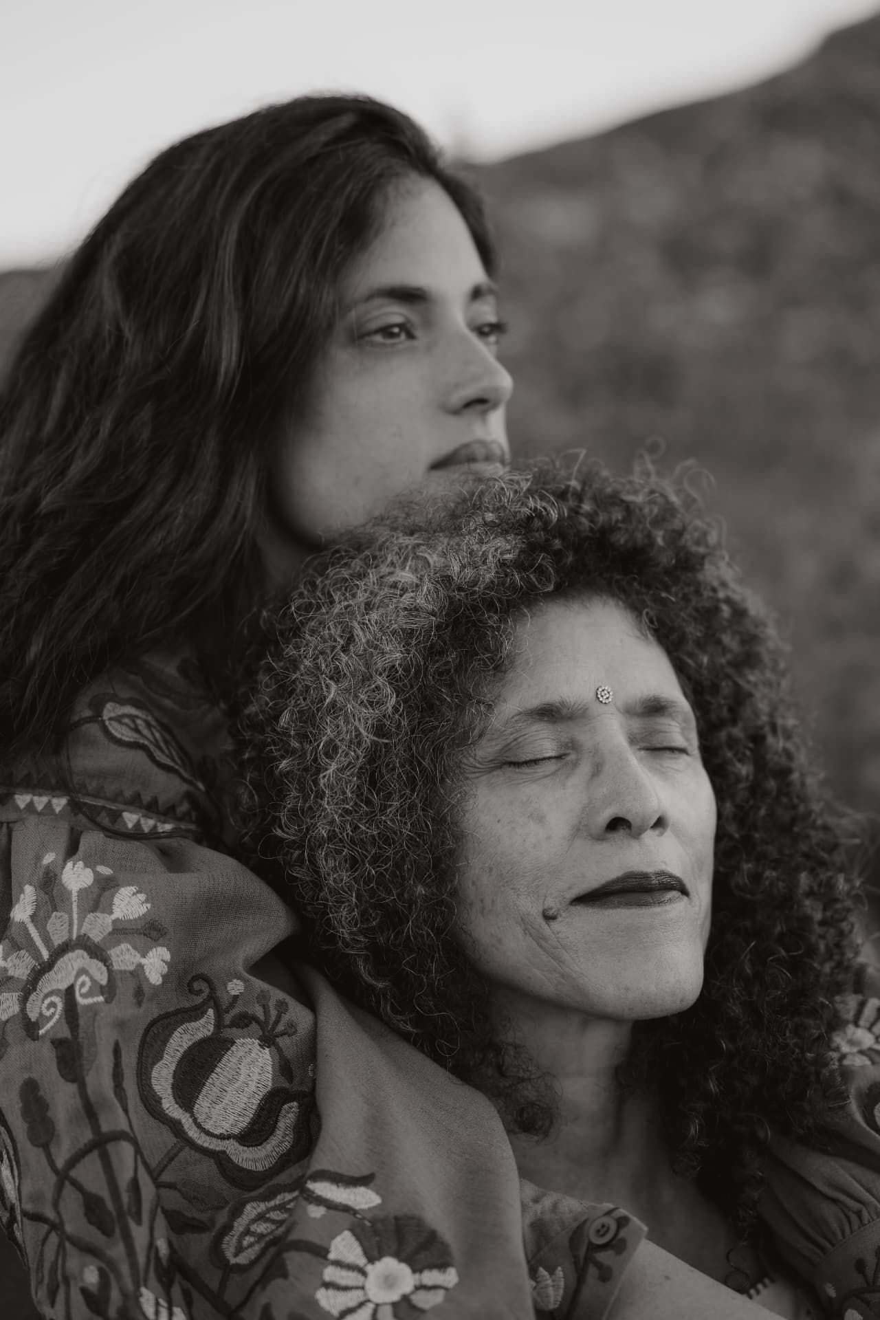 Close portrait of two women leaning together