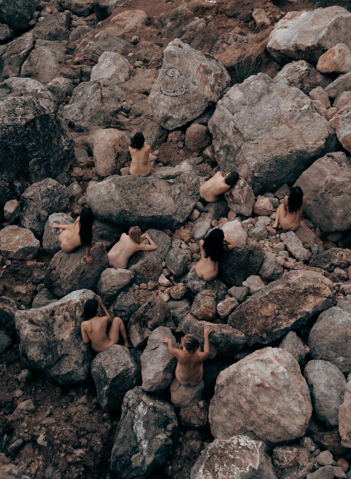 Group of women resting among coastal boulders, seen from above